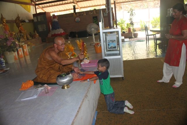 Blessings and tying of the sacred thread by the monk. 