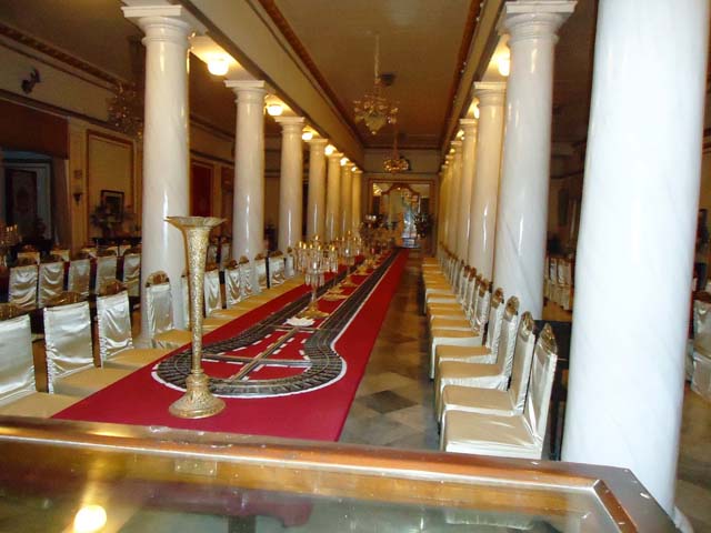 महल का भव्य डाईनिंग हॉल में डाईनिंग टेबल पर चाँदी की ट्रेन से खाना परोसने की व्यवस्था 