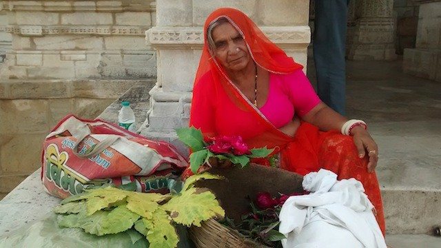मंदिर के बाहर पुष्प बेचती महिला